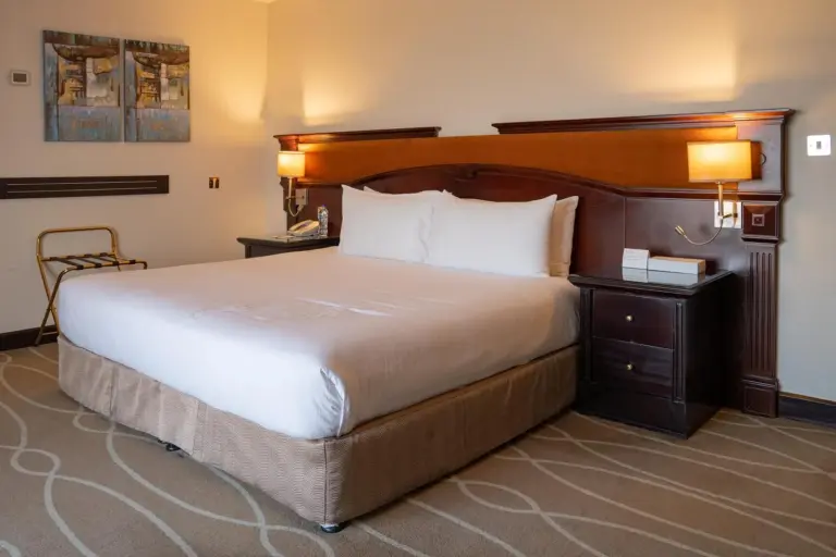 Chambre confortable au Danat Al Ain Resort à Al Ain avec un lit king, des lampes de chevet et une décoration chaleureuse.
