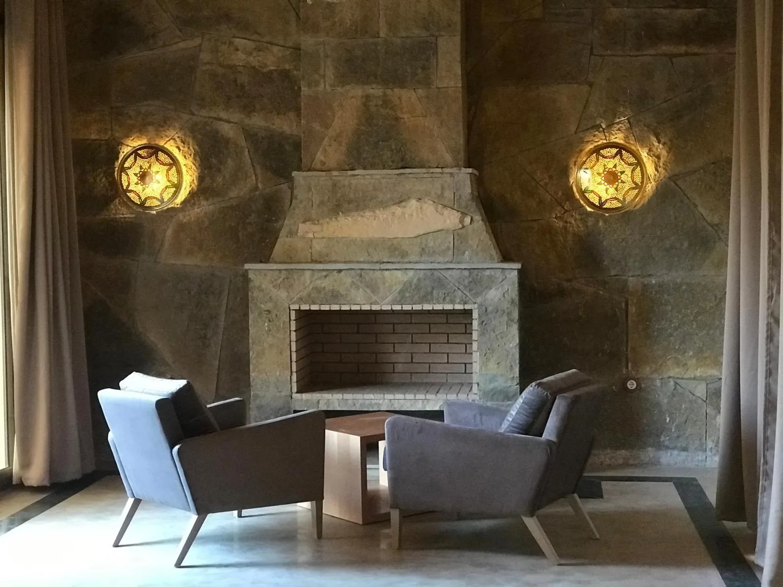 Acogedora zona de estar en el hotel Dar Hnini con paredes de piedra