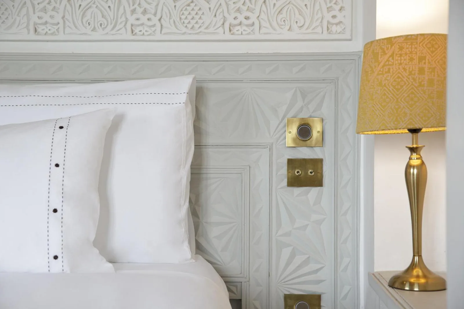 Decoración detallada junto a la cama del hotel Dar Rhizlane