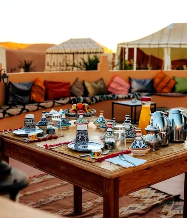 Desert Berber Luxury Camp in Merzouga terrace table with Moroccan tea set and lounge seating
