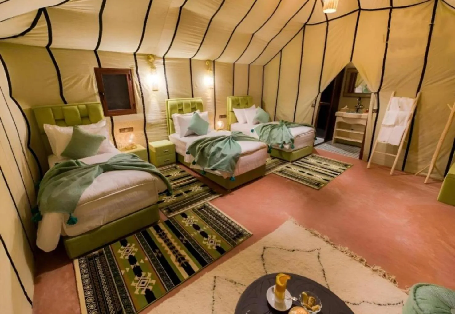 Desert Berber Luxury Camp in Merzouga twin bed guest tent with rugs and seating