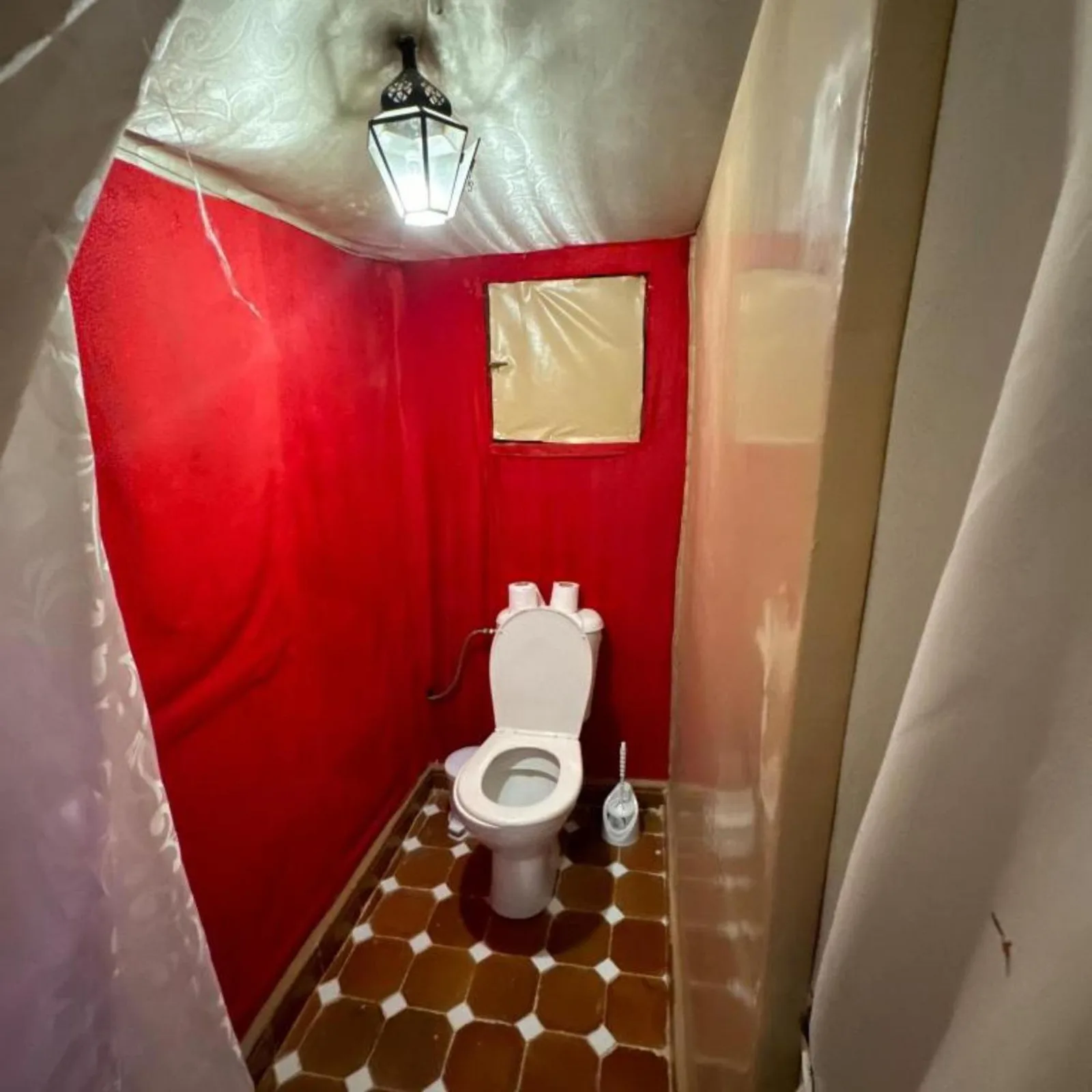 Desert camp merzouga – Merzouga, Morocco hotel – a small bathroom with a toilet in a red room at Desert camp merzouga in Merzouga