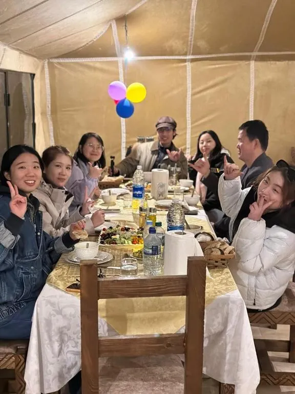 Group of guests enjoying dinner at Desert Nights Camp
