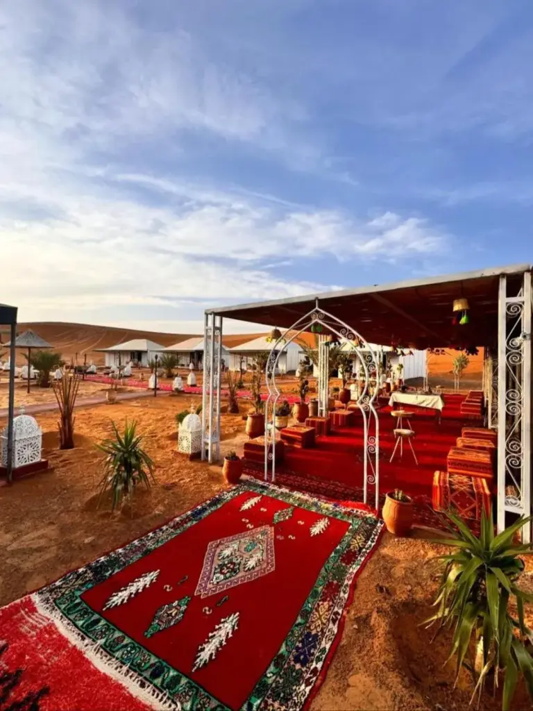 Outdoor-Moroccan-Lounge-Bereich im Desert Pearl Camp Merzouga in Merzouga mit Teppichen und Sitzgelegenheiten in der Wüste