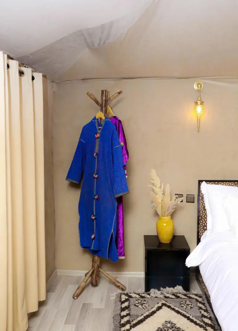 Im Inneren eines Zelts im Desert Pearl Camp Merzouga in Merzouga mit Kleiderständer, Nachttisch und Bett