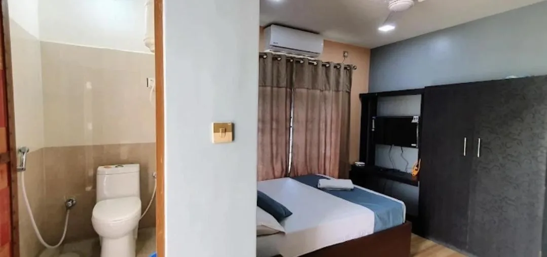 Interior del baño y de la habitación de huéspedes en Devtara Himalayan Hotel en Lumbini con inodoro, cama y armario