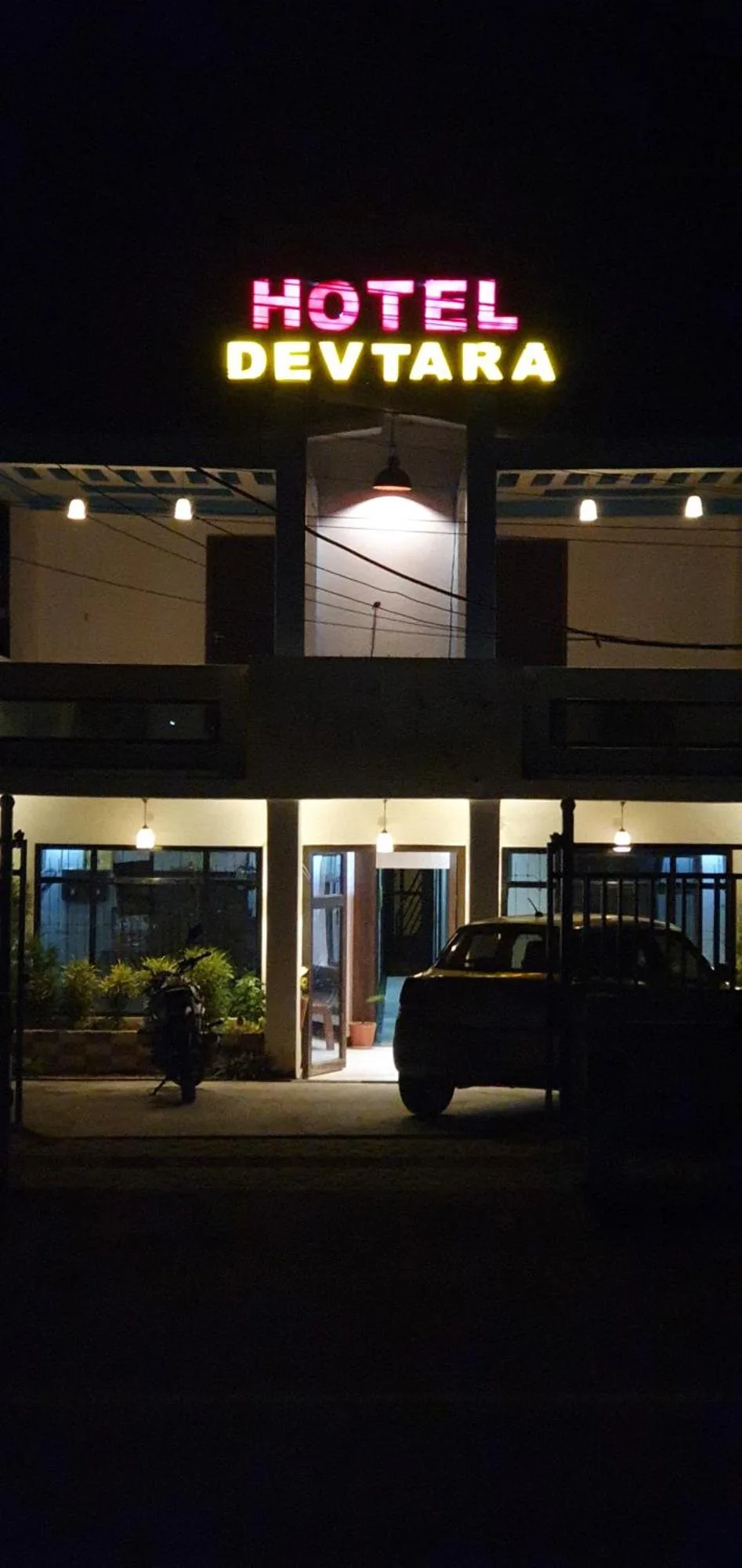 Exterior nocturno de Devtara Himalayan Hotel en Lumbini con letrero iluminado y entrada
