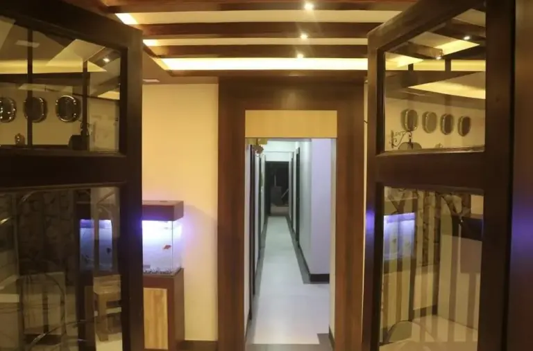 Pasillo interior en Devtara Himalayan Hotel en Lumbini con puertas de cristal e iluminación cálida