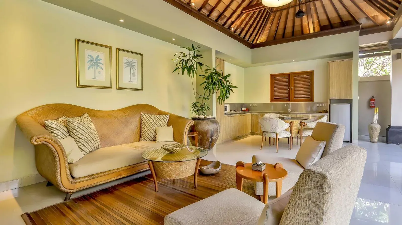 Living room interior at DISINI Luxury Spa Villas-CHSE Certified in Seminyak with sofa, coffee table, dining area, and kitchen