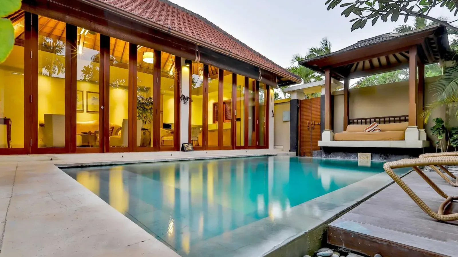 Private pool villa exterior at DISINI Luxury Spa Villas-CHSE Certified in Seminyak with glass doors, tropical courtyard, and cabana