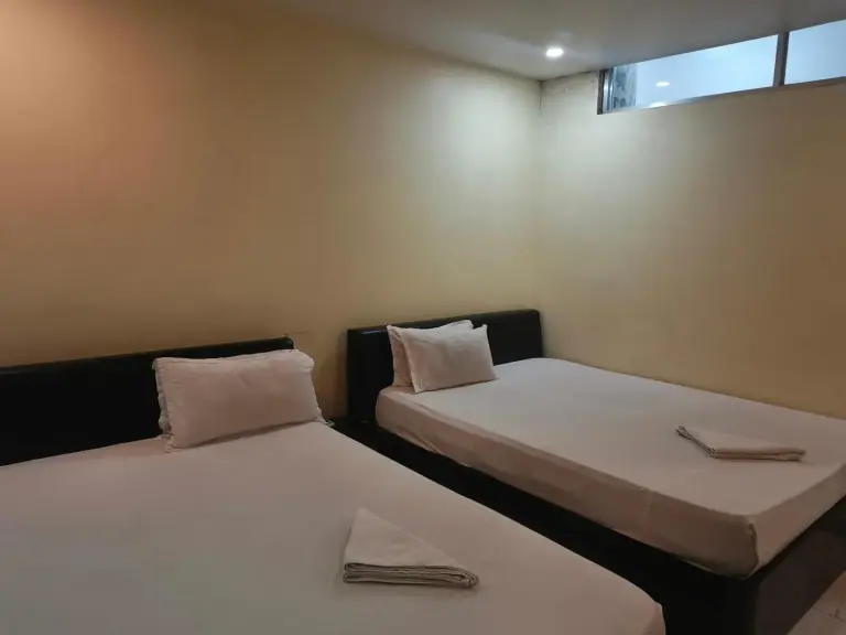 Domukha Pali Ghar twin room in Birtamod with two single beds and simple beige walls.