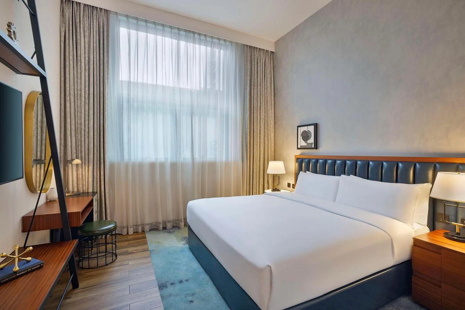 Bright bedroom at DoubleTree by Hilton Dubai M Square Hotel & Residences in Dubai with a king bed and large window