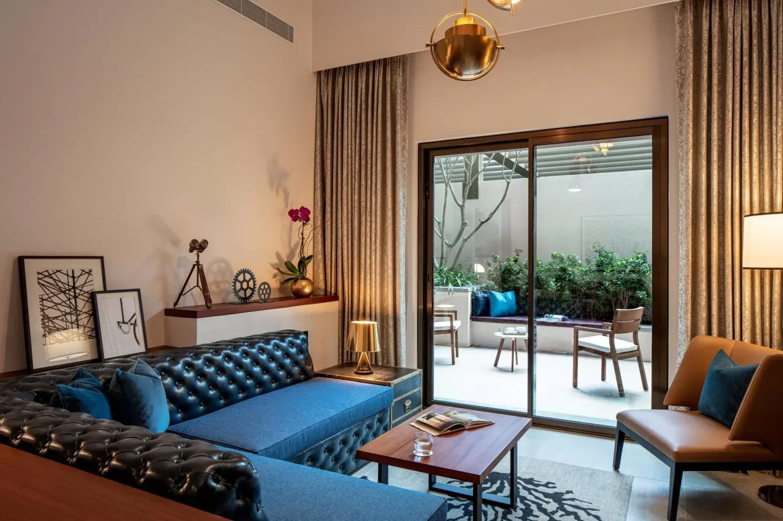 Stylish living area at DoubleTree by Hilton Dubai M Square Hotel & Residences in Dubai with sofa and terrace access