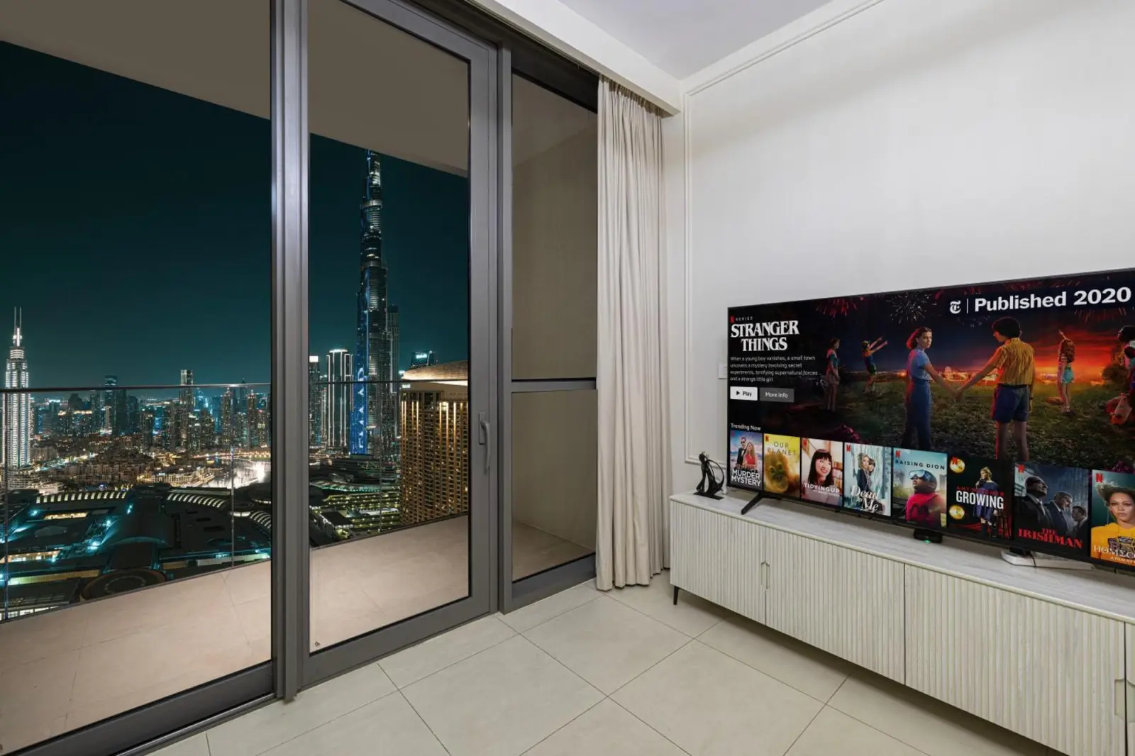 Hotel living room with television and Burj Khalifa night view, Downtown Dubai.