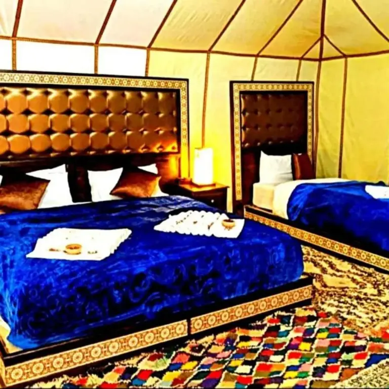 Dream Desert Camp in Merzouga family tent room with blue bedspreads and patterned rugs