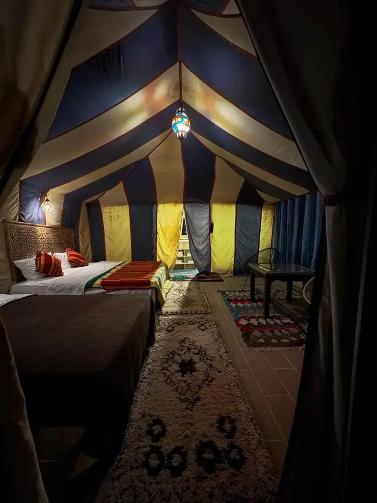 Dream luxury camp in Merzouga tent bedroom with double beds, lantern lighting, and traditional desert furnishings