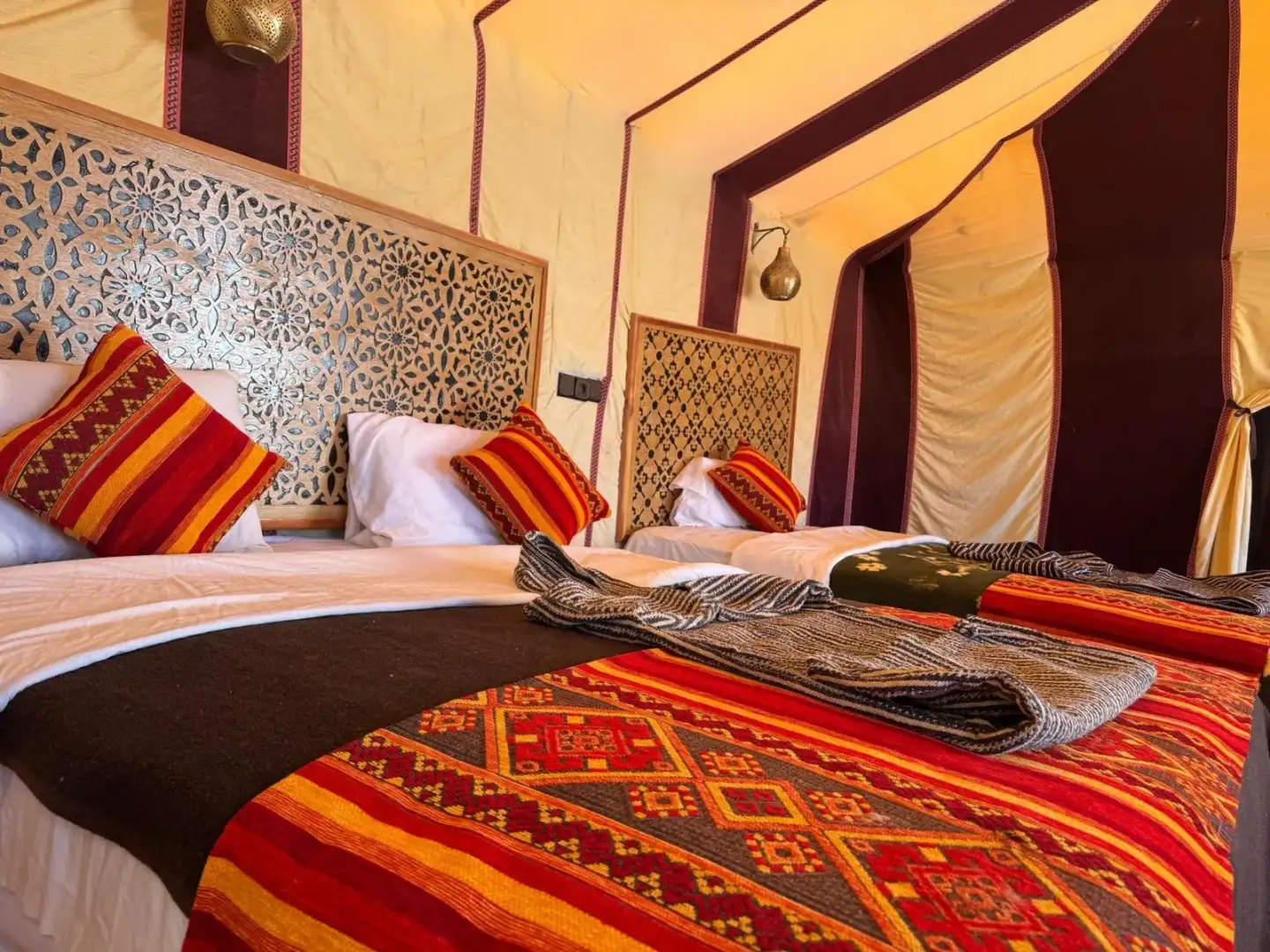 Dream luxury camp in Merzouga twin bed room with ornate headboards and colorful bed runners