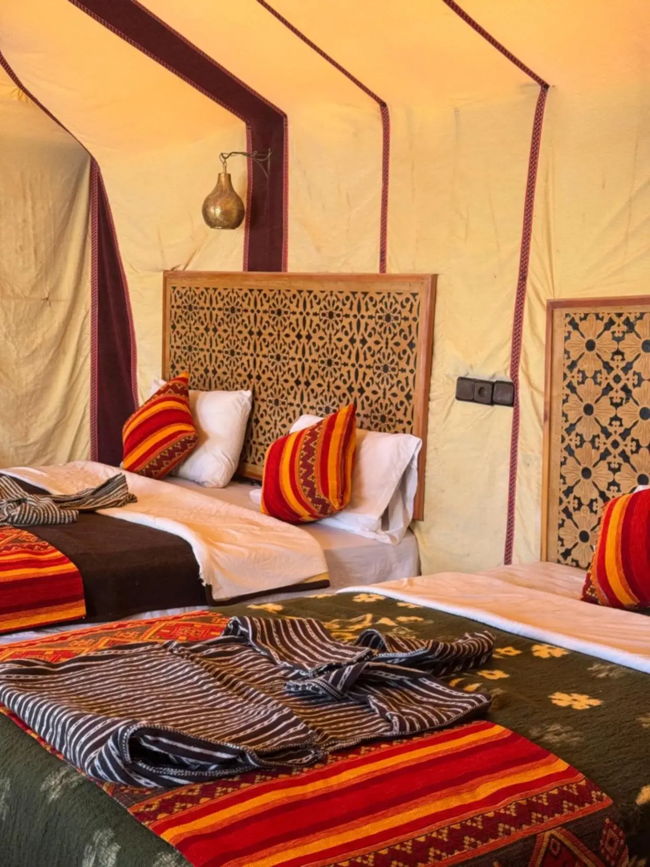 Dream luxury camp in Merzouga twin-bed tent room with woven headboards and warm desert camp decor