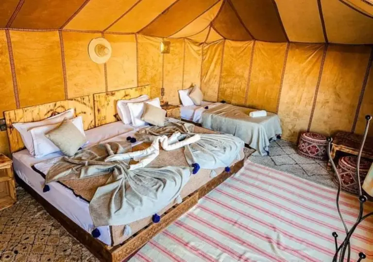 Spacious tent bedroom at Dune Majesty Luxury Camp Merzouga with multiple beds