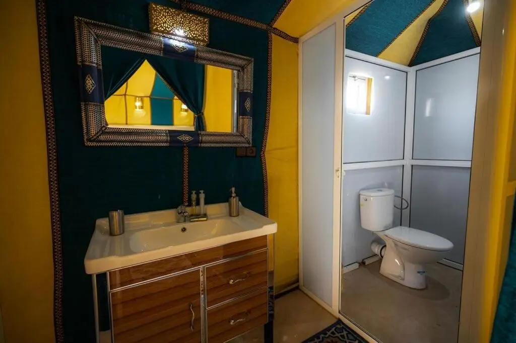 Baño de la tienda amarilla en Dunes Luxury Camp