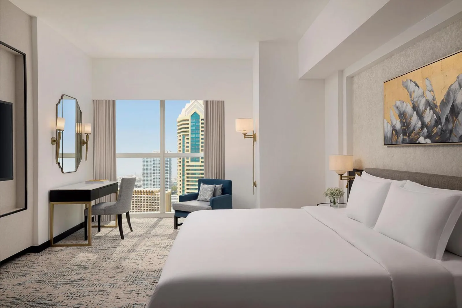 Dormitorio de Dusit Thani Dubai con escritorio, asiento junto a la ventana y skyline de la ciudad