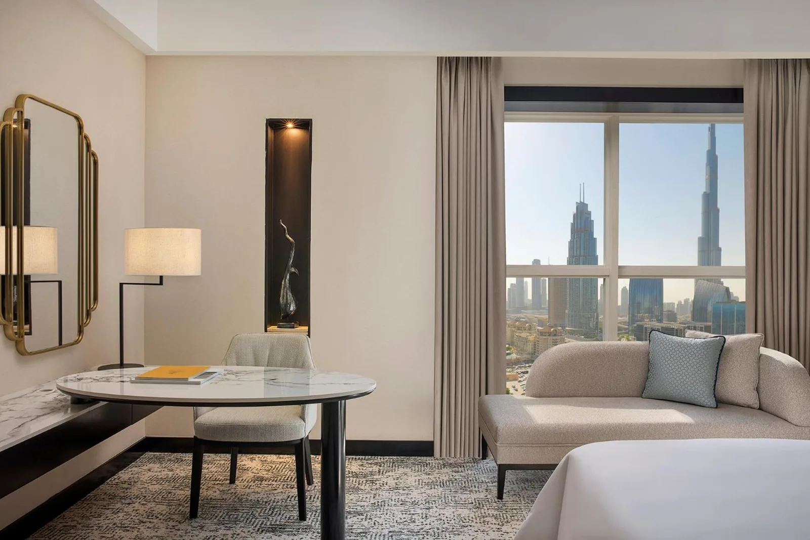 Habitación de Dusit Thani Dubai con escritorio, sillón y vistas al Burj Khalifa