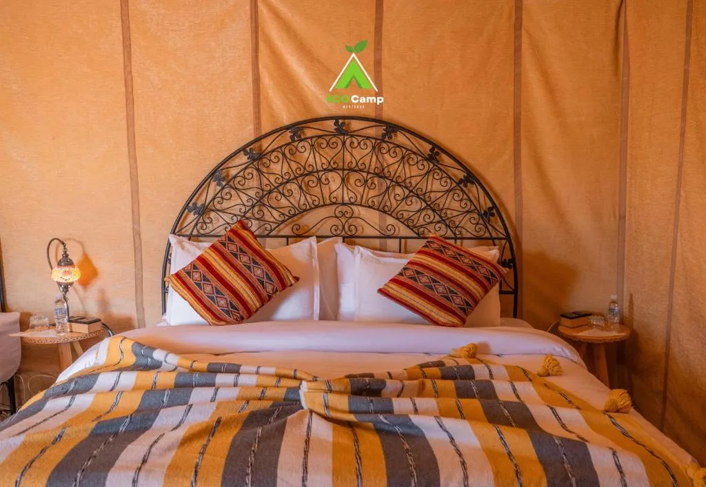 Eco Desert Camp bed with decorative pillows.