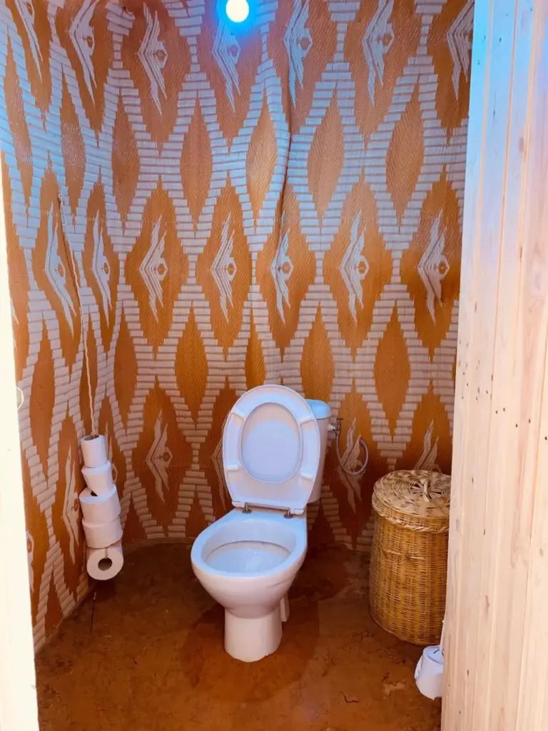 Eco Merzouga luxury camp in Merzouga bathroom with a toilet and patterned desert-style walls