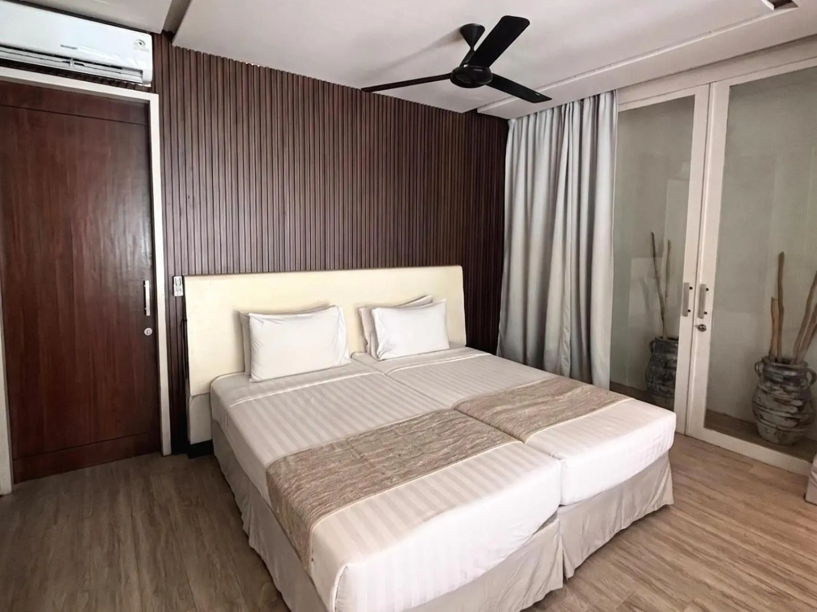 Eden The Residence at The Sea Seminyak – Hotel in Seminyak, Indonesien – ein Bett in einem Zimmer mit einem großen Fenster im Eden The Residence at The Sea Seminyak in Seminyak
