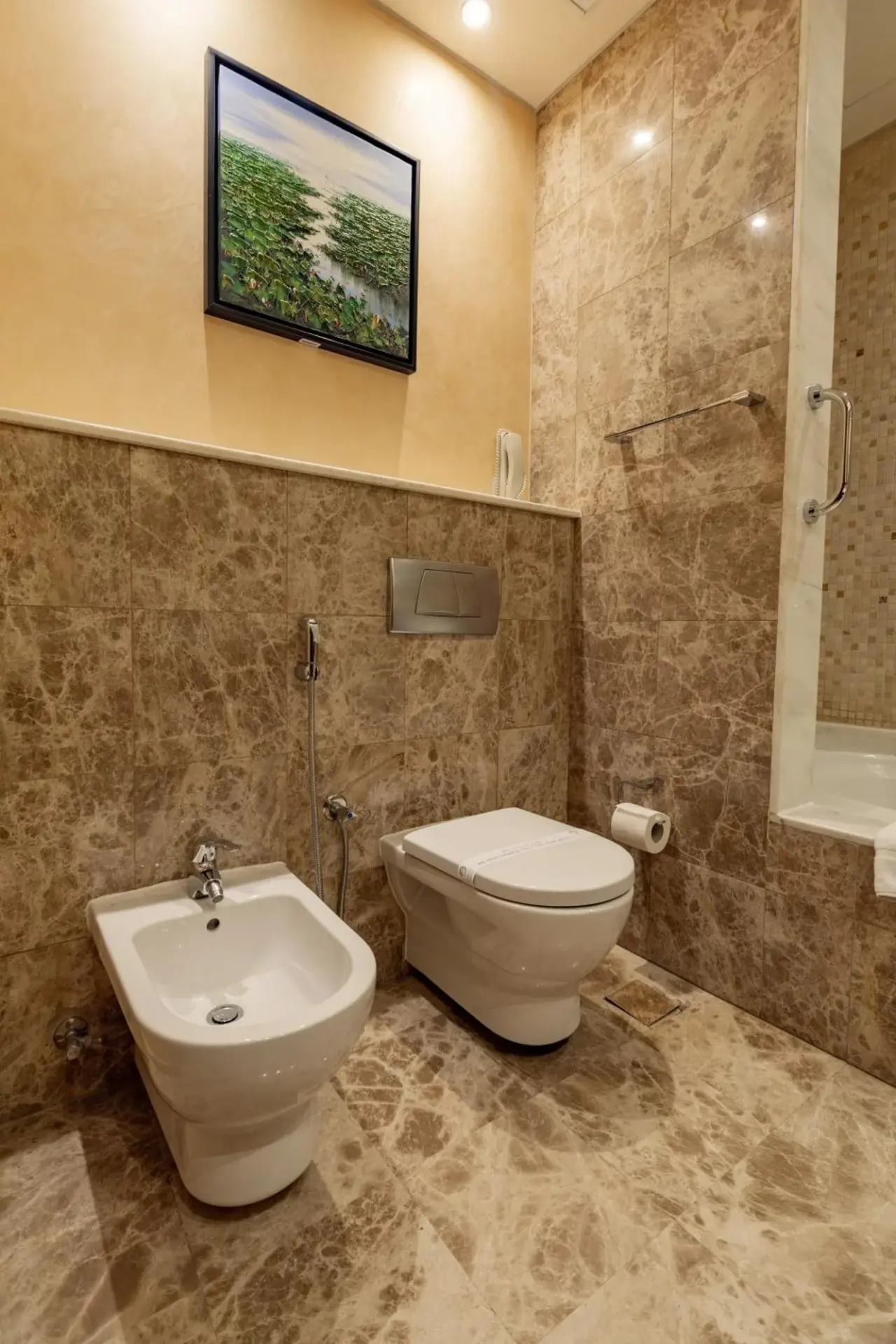Salle de bains moderne à Elite Byblos Hotel Dubai avec baignoire, meuble vasque et miroir