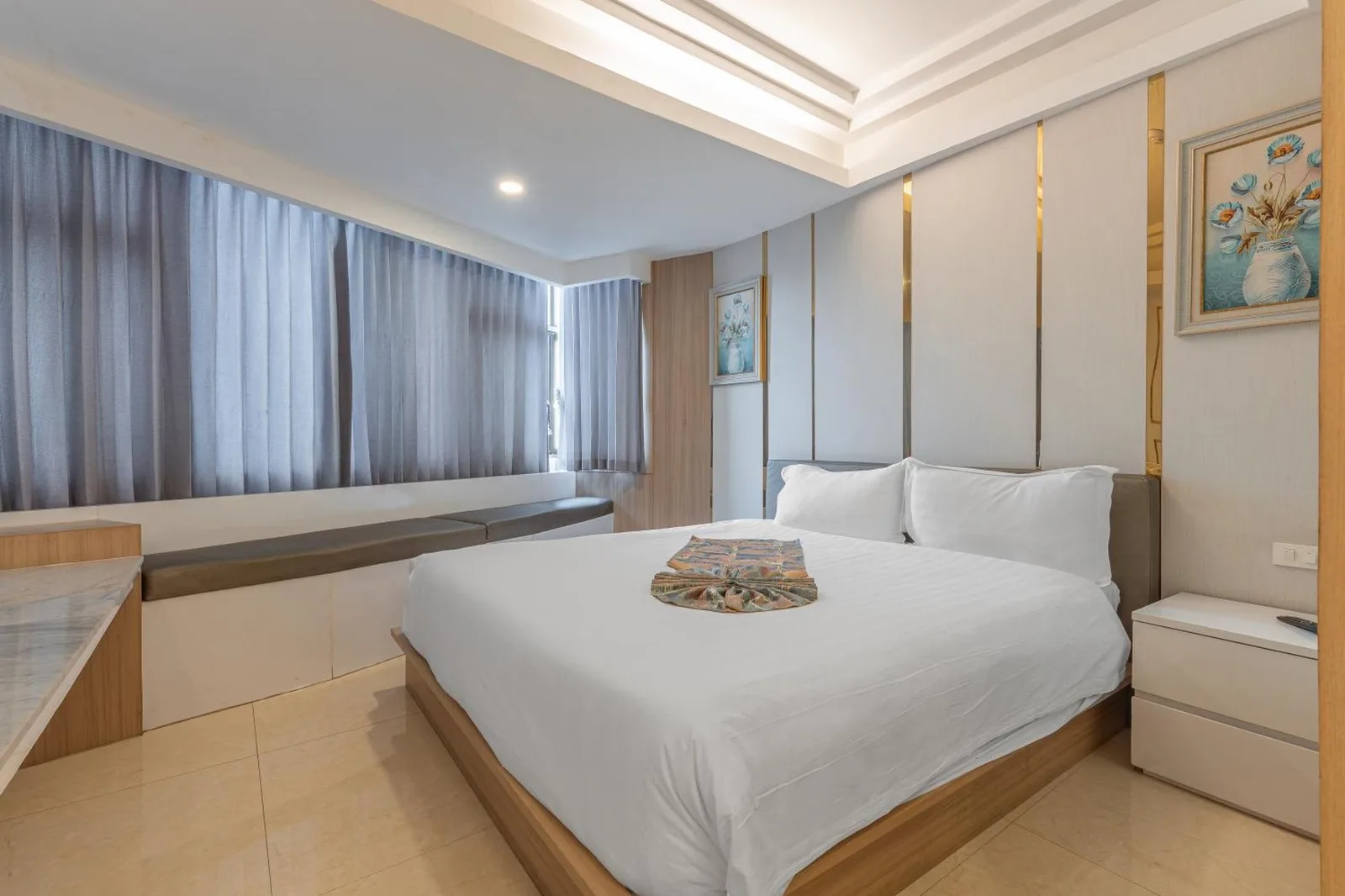 Stylish king bedroom at Elong Hotel Pattaya Jomtien Beach with white linens and modern wall panels
