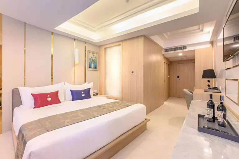 Modern studio room at Elong Hotel Pattaya Jomtien Beach in Pattaya with bed, TV, desk, and minibar