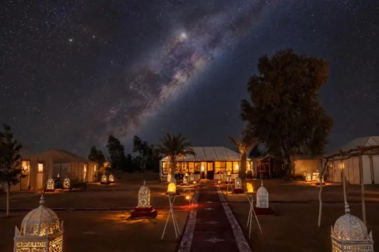 Night exterior of Erg Chebbi Camp & Activities in Merzouga with lanterns and starry sky