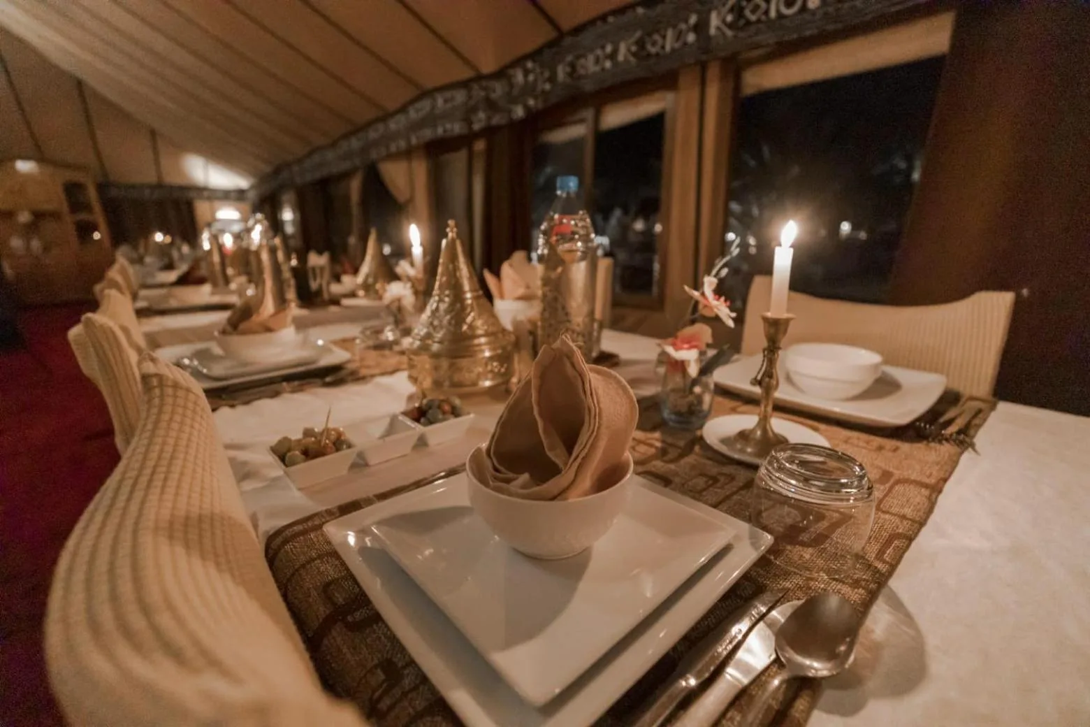 Elegant table setting at Erg Chebbi Desert Camp And Activities in Merzouga with candles and Moroccan decor.