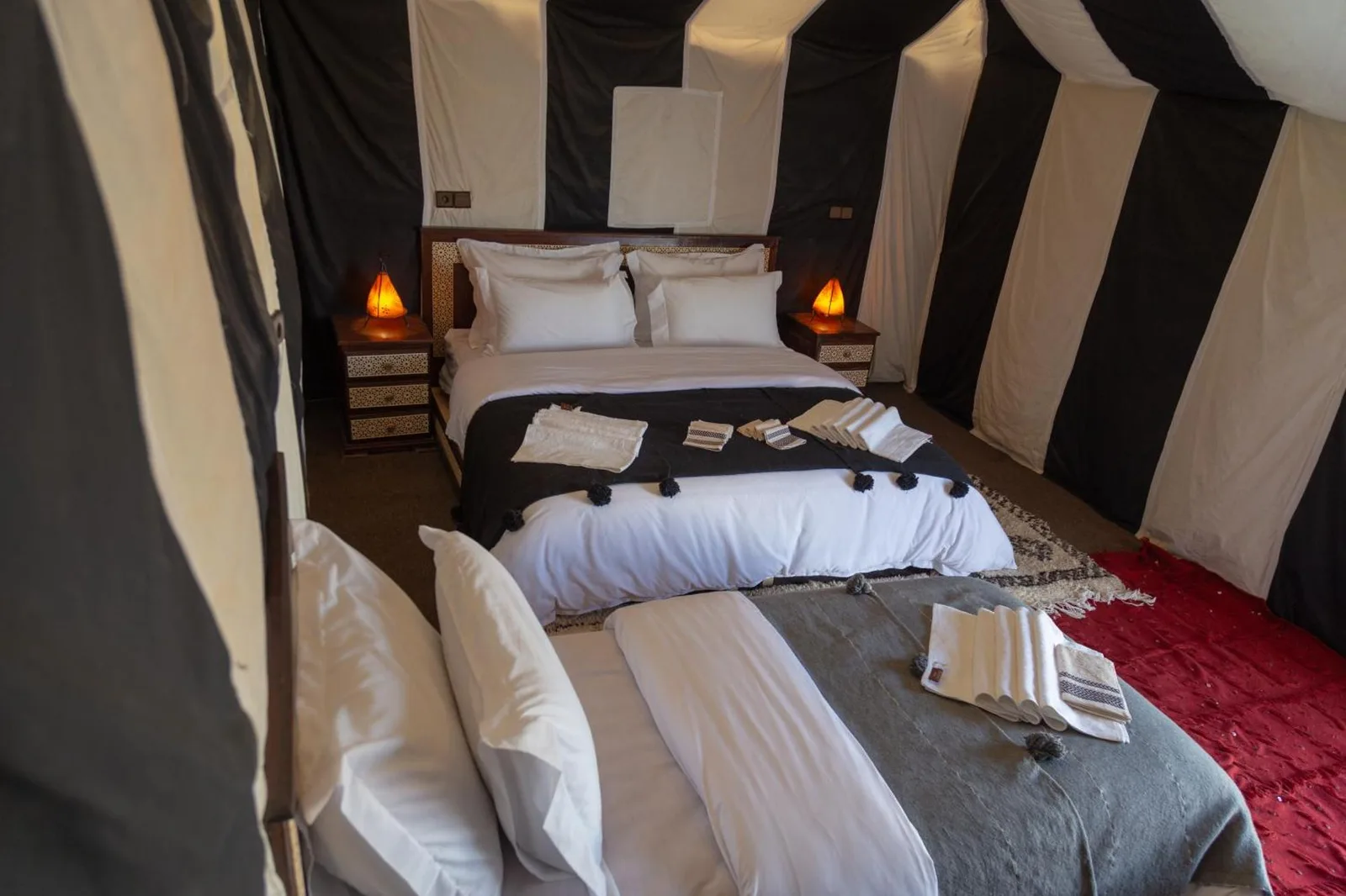 Innenansicht des Deluxe-Zelts von Erg Chebbi Luxury Camp mit bequemen Betten