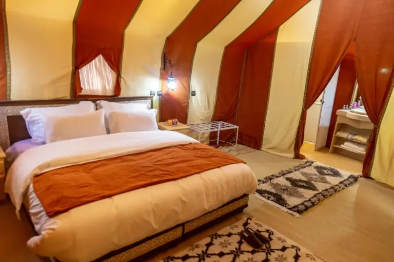 Elegantes Zelt-Schlafzimmer im Erg Chebbi Desert Luxury Camp mit warmer Einrichtung