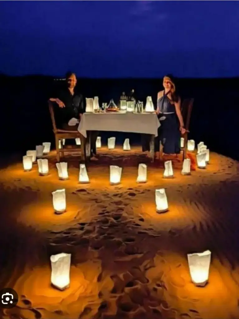Romantic candlelit dinner setup at Erg Chebbi Luxury Camp in Merzouga on the desert sand