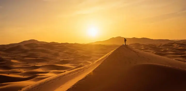 Sunset over the dunes near Erg Chebbi Luxury Camp in Merzouga with a lone figure on a ridge