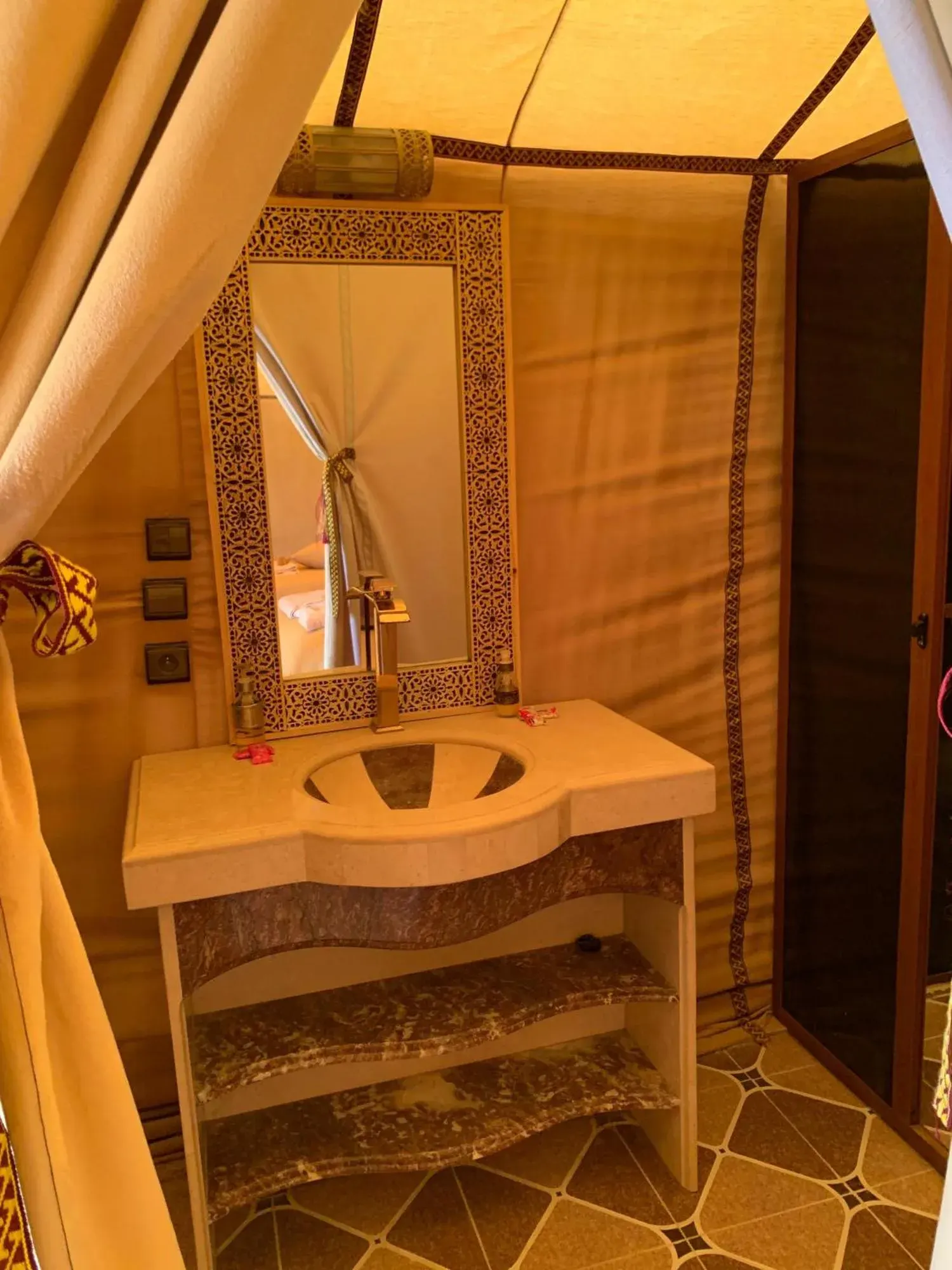 Baño privado de tienda en Erg Dream Luxury Camp en Merzouga, con lavabo, espejo y zona de ducha.