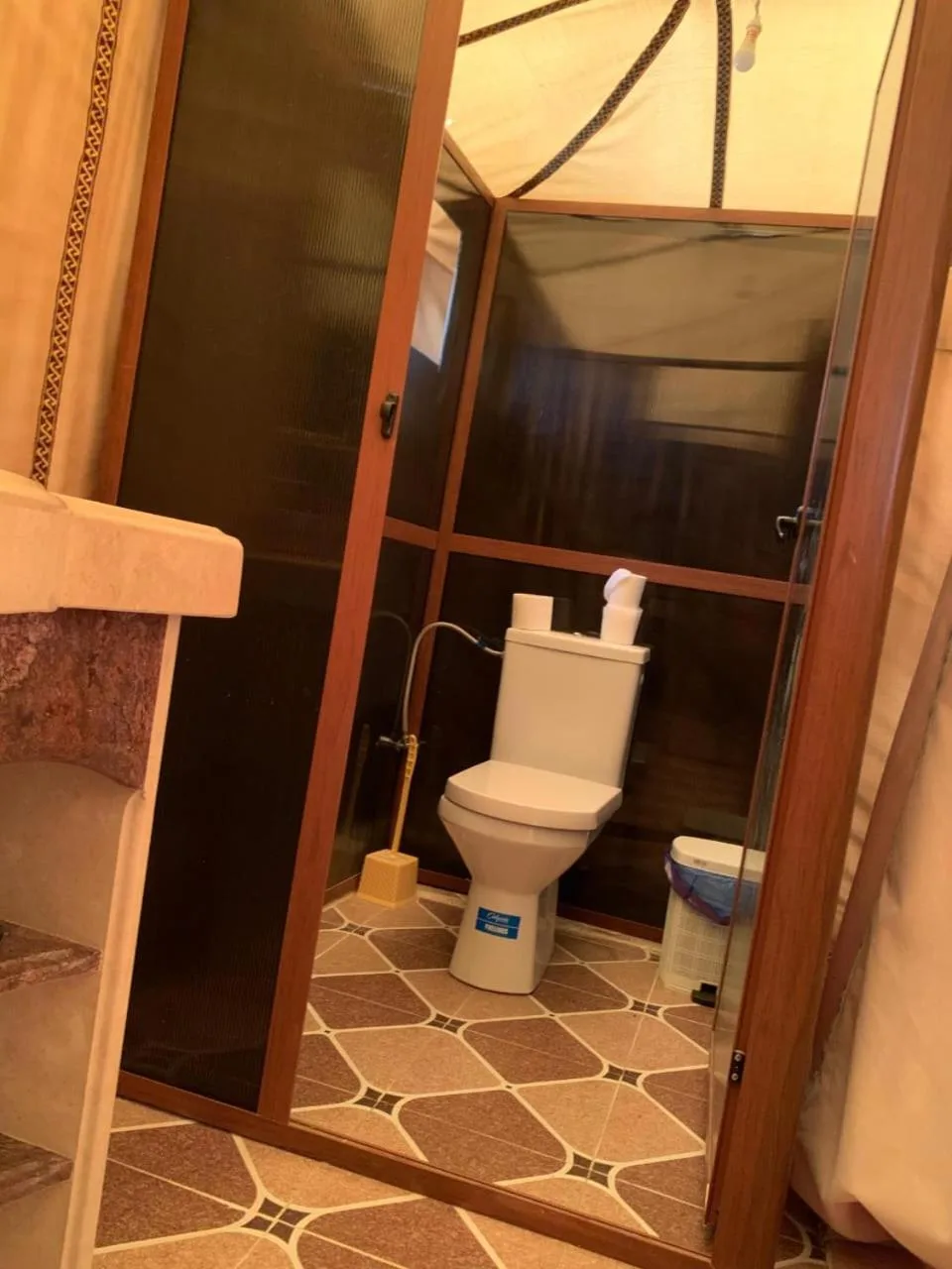 Baño privado de la tienda en Erg Dream Luxury Camp en Merzouga, con inodoro occidental y cabina cerrada.