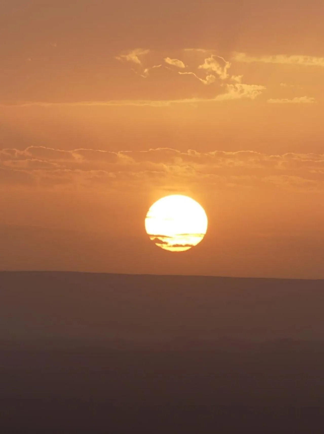 Nahaufnahme der untergehenden Sonne über den Dünen nahe Erg Luxury Camp Merzouga in Merzouga