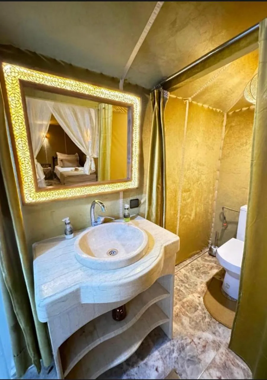 Baño de Expedition Luxury Camp en Merzouga con lavabo de seno redondo, espejo iluminado y inodoro