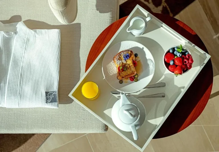Fairmont Bab Al Bahr – Hotel in Abu Dhabi, Vereinigte Arabische Emirate – ein kleiner Tisch mit einem Teller Essen darauf im Fairmont Bab Al Bahr in Abu Dhabi