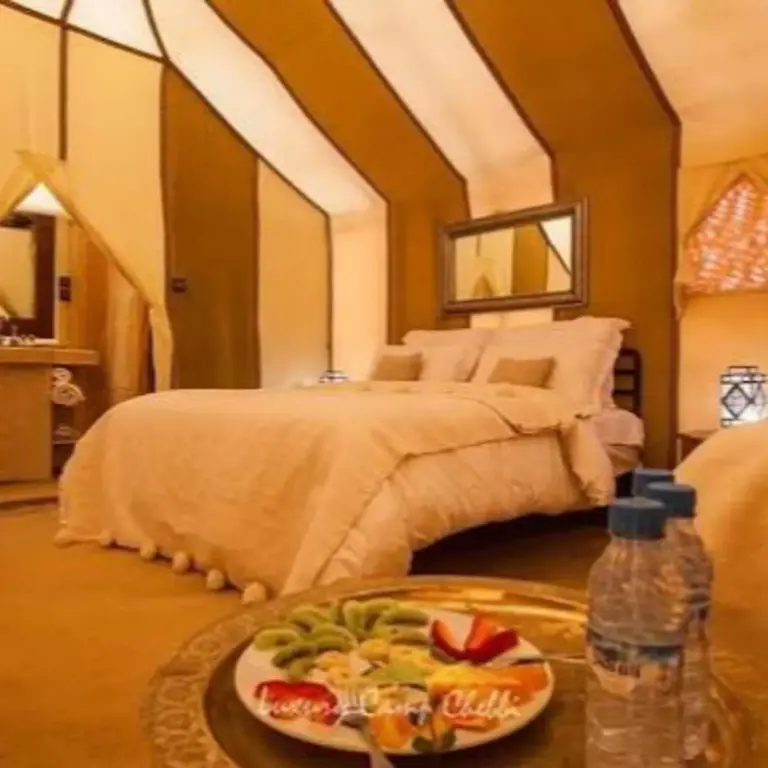 Fancy Golden Luxury Camp – hôtel à Merzouga, Maroc – une chambre avec un lit dans une tente au Fancy Golden Luxury Camp à Merzouga