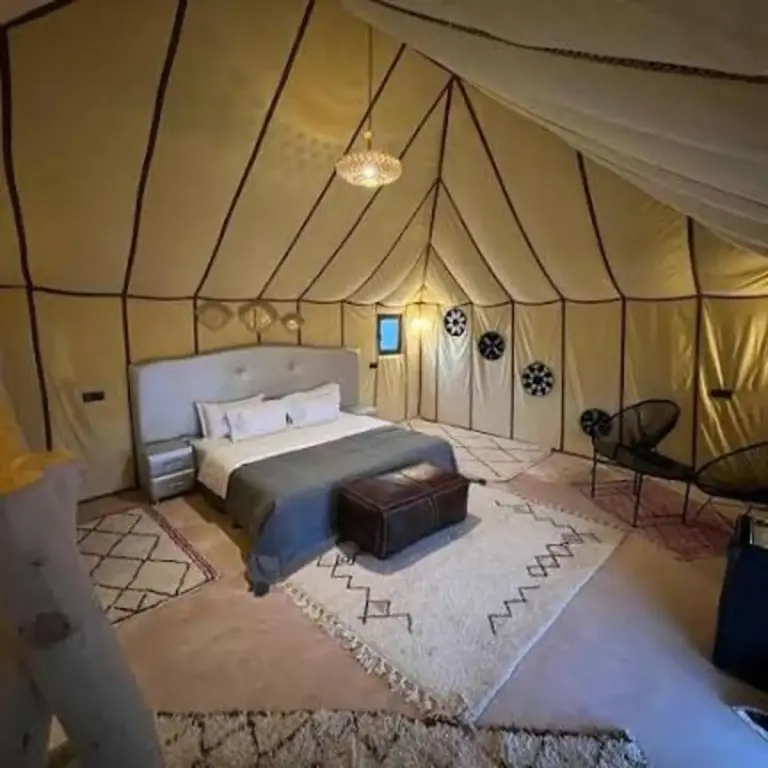 Fancy Golden Luxury Camp – hôtel à Merzouga, Maroc – une chambre avec quatre lits dans une tente au Fancy Golden Luxury Camp à Merzouga