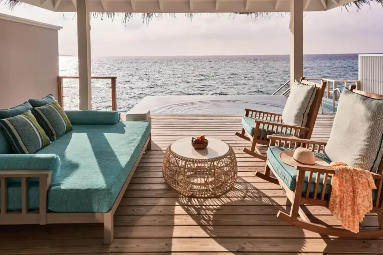 Outdoor lounge area with ocean view at Finolhu, A Seaside Collection Resort.