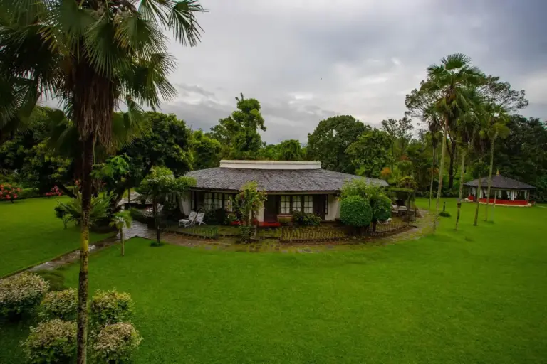 Lawn area and cottages at Fish Tail Lodge in Pokhara with lush surroundings.