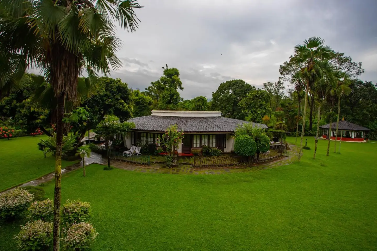 Lawn area and cottages at Fish Tail Lodge in Pokhara with lush surroundings.