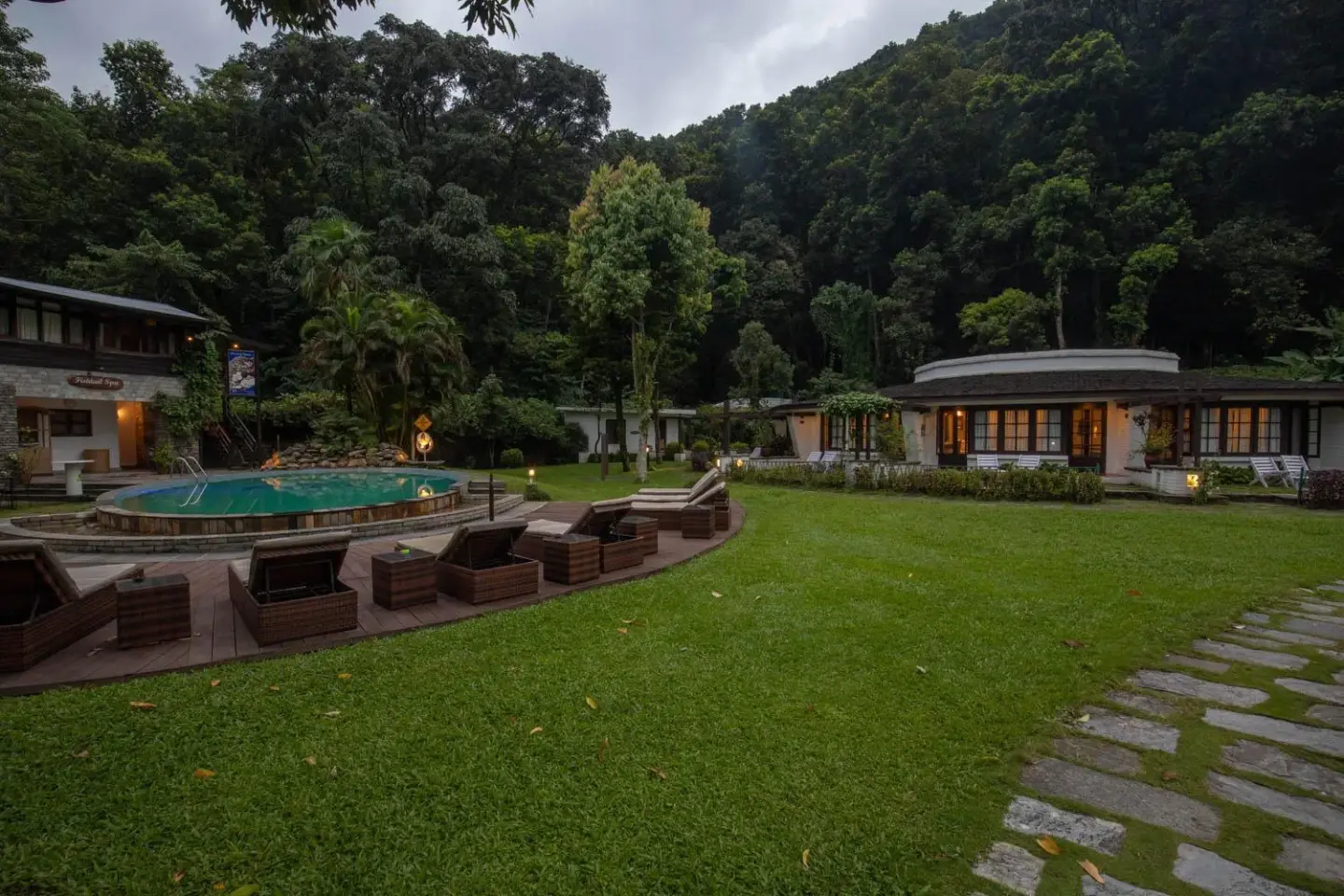 Pool area at Fish Tail Lodge in Pokhara surrounded by greenery.