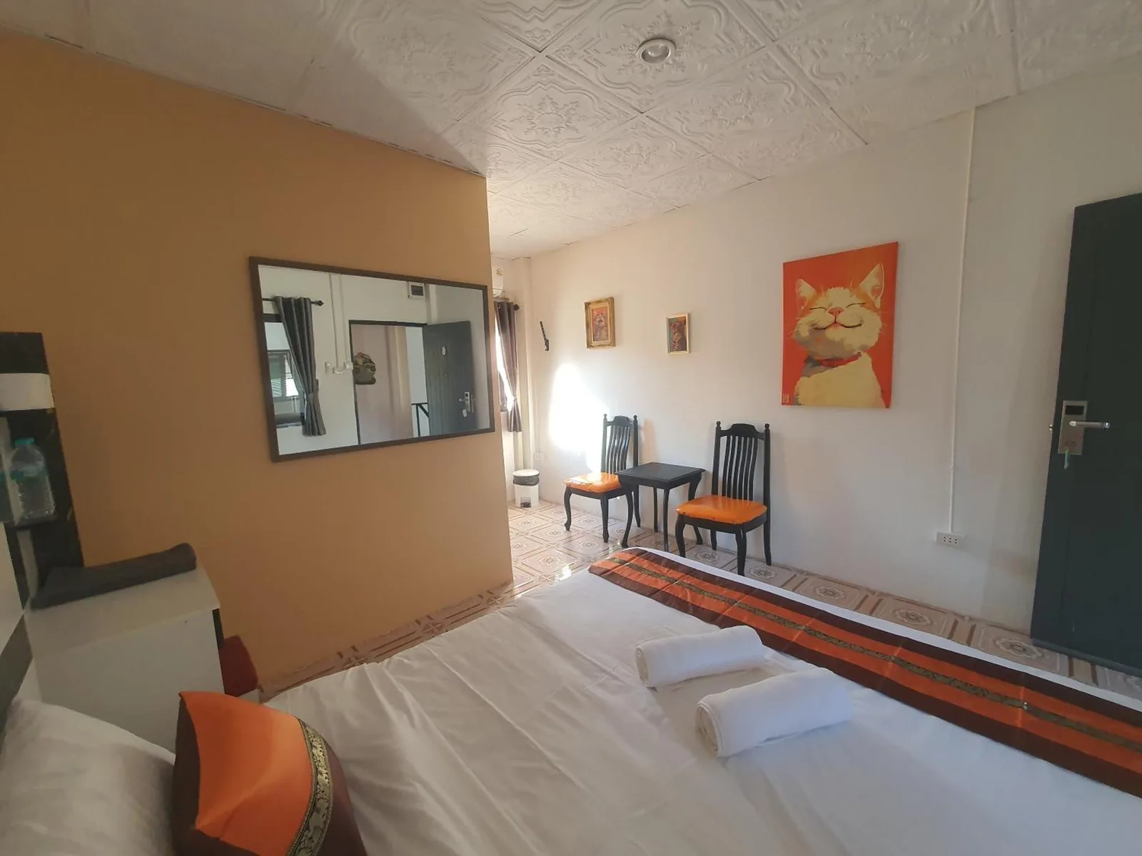 Habitación queen de Forge Boutique Chiang Mai con detalles en naranja y zona de estar